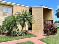 Inviting condo exterior featuring a stucco facade, landscaping, and a covered entryway at 3473 Clark Rd # 171, Sarasota, FL 34231