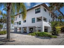 Beautiful three-story townhouse featuring covered parking and lush tropical landscaping at 3701 5Th Ave # 1, Holmes Beach, FL 34217