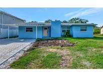 Charming single-story home featuring a covered carport, brick chimney and a freshly landscaped front yard at 4512 26Th S Ave, Tampa, FL 33619