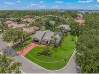 Beautiful home featuring well-manicured landscaping, a circular driveway, and a tile roof in a lush community at 4636 Pine Harrier Dr, Sarasota, FL 34231