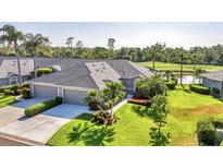 A well-maintained home featuring a two car garage, lush landscaping, and verdant lawn at 5217 Chase Oaks Dr, Sarasota, FL 34241