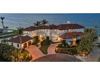 Stunning waterfront home with lush landscaping, circular driveway, and Mediterranean-style architecture at 641 Ranger Ln, Longboat Key, FL 34228