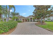 Stately home with a lush, landscaped front yard and circular driveway at 6919 Dominion Ln, Lakewood Ranch, FL 34202