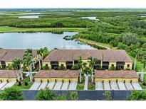 Beautiful condo building exterior featuring tropical landscaping and tile roofs at 7315 River Hammock Dr # 101, Bradenton, FL 34212