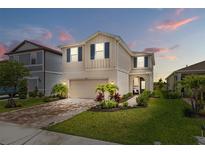 Charming two-story home features landscaped yard, brick driveway, and attached garage at 11430 Gallatin Trl, Parrish, FL 34219