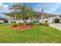 Charming home featuring a landscaped front yard with a beautiful palm tree at 1507 45Th Avenue E Dr, Ellenton, FL 34222