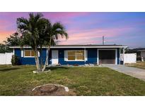 Charming curb appeal with well-maintained lawn and blue exterior on this cozy single-Gathering home at 3095 Pinetree St, Port Charlotte, FL 33952