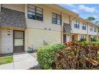 Inviting townhouse exterior with tan siding, front door, manicured bushes, and a small front yard at 3610 54Th W St # B4, Bradenton, FL 34209