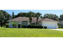 Charming single-story home featuring a lush lawn, well-manicured landscaping, and an attached two-car garage at 3984 Holin Ln, North Port, FL 34287