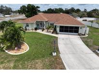 Charming single-story home with well-manicured lawn, decorative landscaping, and long driveway at 3984 Holin Ln, North Port, FL 34287