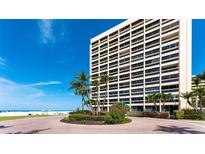 Luxury high-rise condo building overlooking a beautiful beach with tropical landscaping at the entry at 5966 Midnight Pass Rd # G-51 & G-58, Sarasota, FL 34242