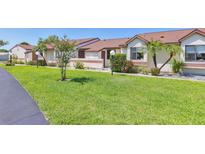 Charming single-story townhome with a well-maintained lawn and tropical landscaping at 6010 36Th Avenue W Cir # E, Bradenton, FL 34209