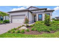 Charming single-story home featuring a well-manicured lawn, an attached two-car garage, and beautiful landscaping at 6244 Talon Preserve Dr, Nokomis, FL 34275