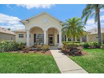 Charming single-story home with a well-manicured lawn, beautiful landscaping, and welcoming covered front porch at 750 Anna Hope Ln, Osprey, FL 34229