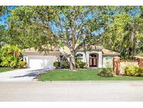 Charming single-story home with a well-manicured lawn and mature trees shading the entrance at 104 Park Trace Blvd, Osprey, FL 34229