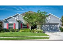 Charming single-story home with a well-manicured lawn, a two car garage, and colorful shutters at 11924 Persian Ter, Bradenton, FL 34212