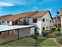 Condo with covered parking, white exterior and beautiful landscaping at 1211 Capri Isles Blvd # 26, Venice, FL 34292