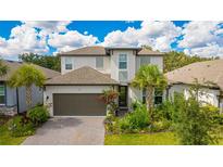 Charming two-story home featuring a well-manicured lawn and a beautiful, attached two car garage at 14921 Barrows Bluff Ter, Bradenton, FL 34212