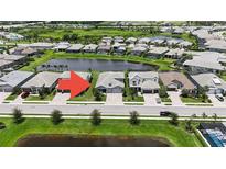A high angle view of a well-maintained home with a beautiful water view and manicured landscaping at 16905 Sweetwater Village Dr, Bradenton, FL 34211