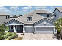Beautiful single-Gathering home with a gray roof and three-car garage on a sunny day at 16905 Sweetwater Village Dr, Bradenton, FL 34211