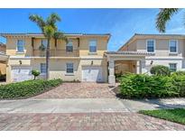 Charming townhome featuring a private garage, covered parking, balcony, and lush landscaping at 1831 Burgos Dr, Sarasota, FL 34238