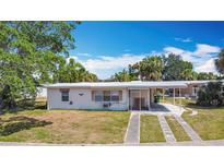 Charming single story home with a covered carport and a well-manicured front lawn at 21966 Belinda Ave, Port Charlotte, FL 33952