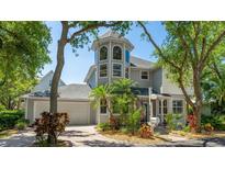 Charming gray home with a tower, lush landscaping, brick driveway, and a two-car garage at 2306 64Th W St # 17, Bradenton, FL 34209