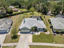 Charming single Gathering home featuring a spacious lawn, attached garage, and screened-in backyard pool at 245 Woodingham Trl, Venice, FL 34292