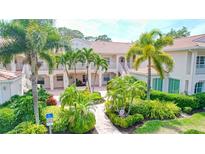 Elegant two-story building with lush tropical landscaping and private balconies at 4264 Central Sarasota Pkwy # 116, Sarasota, FL 34238