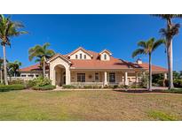 Stunning single-Gathering home with a tile roof, manicured lawn, and decorative columns at 4700 Mainsail Dr, Bradenton, FL 34208