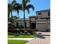 Charming two-story home features lush landscaping, a brick driveway, and a welcoming entrance with stone accents at 535 Honeyflower Loop, Bradenton, FL 34212
