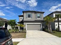 Beautiful two story home with gray tones, well manicured landscaping, and a large driveway at 5521 Summit Gln, Bradenton, FL 34203