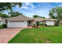 Charming single-story home featuring a well-manicured lawn, brick driveway, and a two-car garage at 5705 Garden Lakes Majestic, Bradenton, FL 34203