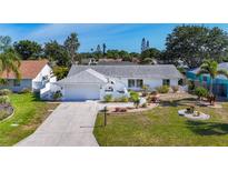 Charming single-story home with a well-manicured lawn, beautiful landscaping, and a spacious driveway leading to an attached garage at 6012 11Th W Ave, Bradenton, FL 34209