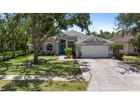 Charming single-story home features a manicured lawn, gray exterior, and a bright blue front door at 6617 Cheswick St, Sarasota, FL 34243
