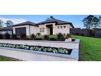Charming single-story home boasts fresh landscaping, a modern design, and a welcoming entrance at 6875 Beckwith Ave, North Port, FL 34291