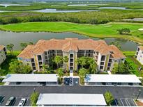 Stunning condo building featuring a tile roof, lush landscaping, and convenient parking at 7019 River Hammock Dr # 306, Bradenton, FL 34212