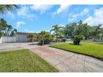 Charming single-story home with well-manicured lawn, palm trees, and brick driveway at 7508 9Th N Ave, St Petersburg, FL 33710