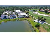 An aerial view of a waterfront home situated on a golf course with beautiful landscaping and outdoor patio at 7728 Club Ln, Sarasota, FL 34238