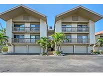 A well maintained condominium exterior shows covered parking and balconies with tropical plants adding to the landscape at 1159 Lake House Cir # C120, Sarasota, FL 34242