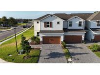 Charming two-story townhouse featuring a brick driveway and a two-car garage at 1824 Woodleaf Hammock Ct, Bradenton, FL 34211