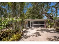 Driveway with lush landscaping and a garage with large windows at 2207 Hickory Ave, Sarasota, FL 34234