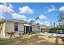 Charming single-story home with a well-manicured lawn, beautiful plants, and a screened-in front porch at 2371 Manheim Ave, North Port, FL 34286
