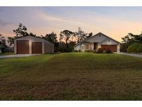 Charming home with lush front lawn and detached garage, perfect for storage or hobbies at 4466 Manila Ave, North Port, FL 34288