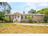 Charming home featuring a well-manicured lawn, cozy front porch, and colorful landscaping at 4922 18Th E St, Bradenton, FL 34203