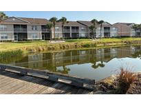 Apartment complex with balconies overlooking a tranquil pond and lush landscaping at 5330 Hyland Hills Ave # 2314, Sarasota, FL 34241
