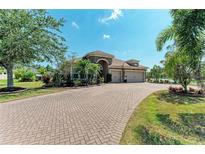 Beautiful single-story home featuring a three-car garage, well-manicured lawn and an elegant paver driveway at 5439 74Th E Pl, Ellenton, FL 34222