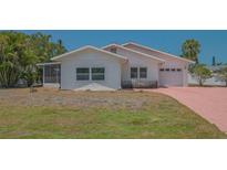 Charming single-story home with a light exterior, a garage, and a brick driveway at 5522 Calle Del Verano, Sarasota, FL 34242