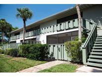 Charming condo exterior with lush landscaping, secure gate, and inviting stairs at 600 Manatee Ave # 143, Holmes Beach, FL 34217