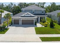 Beautiful two-story home showcasing a three-car garage and a well-manicured lawn at 6017 Maidenstone Way, Palmetto, FL 34221
